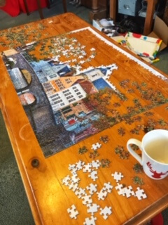 Image of a half completed jigsaw puzzle on a coffee table. Jigsaws are one of the many relaxing hobbies for teachers.